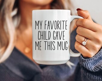 May include: White ceramic mug with black text that reads "My favorite child gave me this mug".