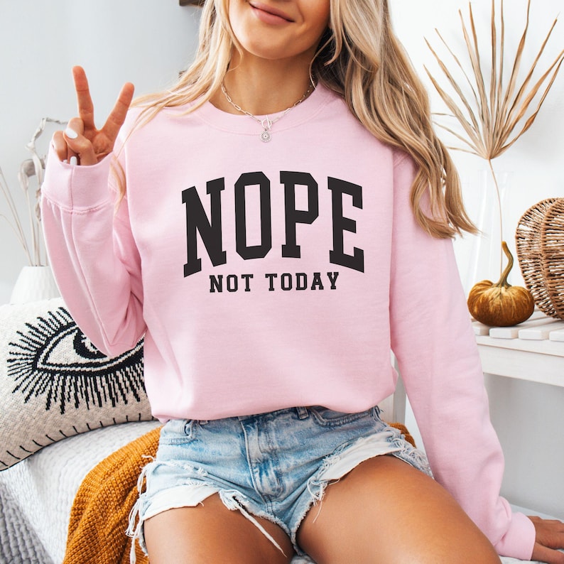 May include: A pink sweatshirt with the text "NOPE NOT TODAY" in black lettering.