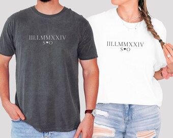 May include: Two t-shirts with the text "III.I.MMXXVI S♡O" printed on them. The t-shirts are in different colors, one is dark gray and the other is white.