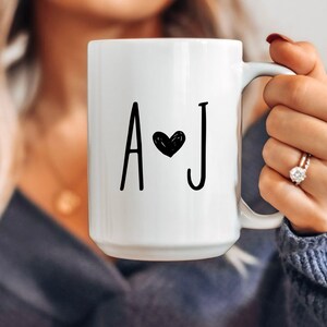 May include: White ceramic mug with black lettering that says "A ♥ J".