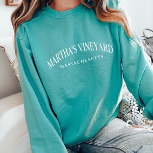 May include: A teal blue sweatshirt with the text "Martha's Vineyard Massachusetts" in white.
