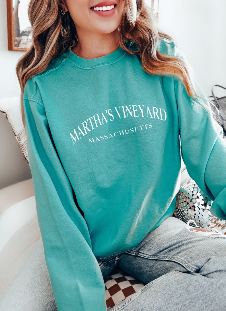 May include: A teal blue sweatshirt with the text "Martha's Vineyard Massachusetts" in white.