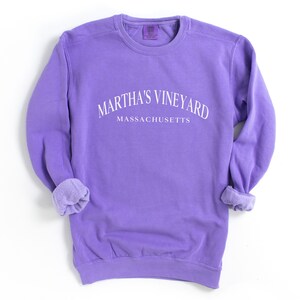 May include: Purple sweatshirt with the text "Martha's Vineyard Massachusetts" in white.