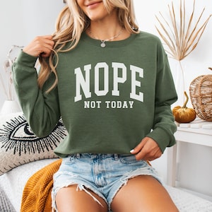 May include: A green sweatshirt with the text "NOPE NOT TODAY" in white letters. The sweatshirt is a relaxed fit and has a crew neck.