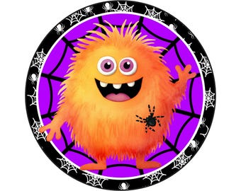 May include: A round orange monster with a big smile and pink eyes is surrounded by a black and white spider web design on a purple background.