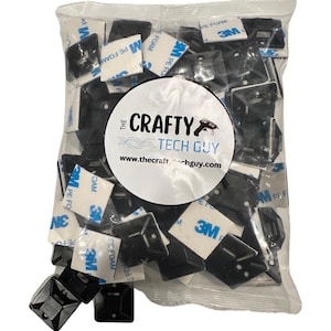 May include: A bag of black adhesive mounting squares with 3M adhesive backing. The bag has a white label with the text "THE CRAFTY TECH GUY" and a website address.