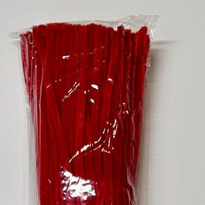 May include: A pack of red pipe cleaners. The pipe cleaners are bundled together and wrapped in clear plastic.