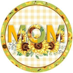 Könnte beinhalten: Ein rundes, grün-gelbes Schild mit kariertem Hintergrund und dem Wort "MOM" in großen, gelben Buchstaben. Die Buchstaben sind von einem Kranz aus Sonnenblumen und Bienen umgeben.