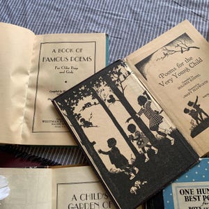 Pu&ograve; includere: Diversi libri per bambini d'epoca sono aperti ed esposti. Le copertine presentano illustrazioni e titoli come "A Book of Famous Poems" e "Poems for the Very Young Child". I libri sono in vari stati di usura, con carta invecchiata.