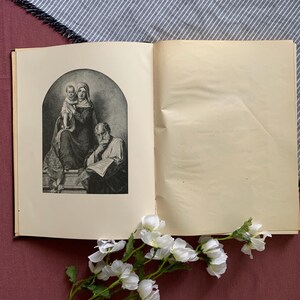 Peut inclure: Un livre ouvert avec une illustration en noir et blanc d'une famille. L'illustration montre une femme tenant un enfant et un homme lisant un livre. Le livre est sur un fond blanc.