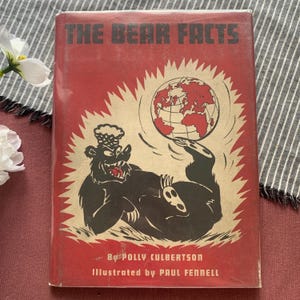 Può includere: Un libro con copertina rigida rossa intitolato The Bear Facts di Polly Culbertson, illustrato da Paul Fennell. La copertina presenta un orso nero dei cartoni animati sdraiato che bilancia un globo sul piede, circondato da un motivo a raggiera.