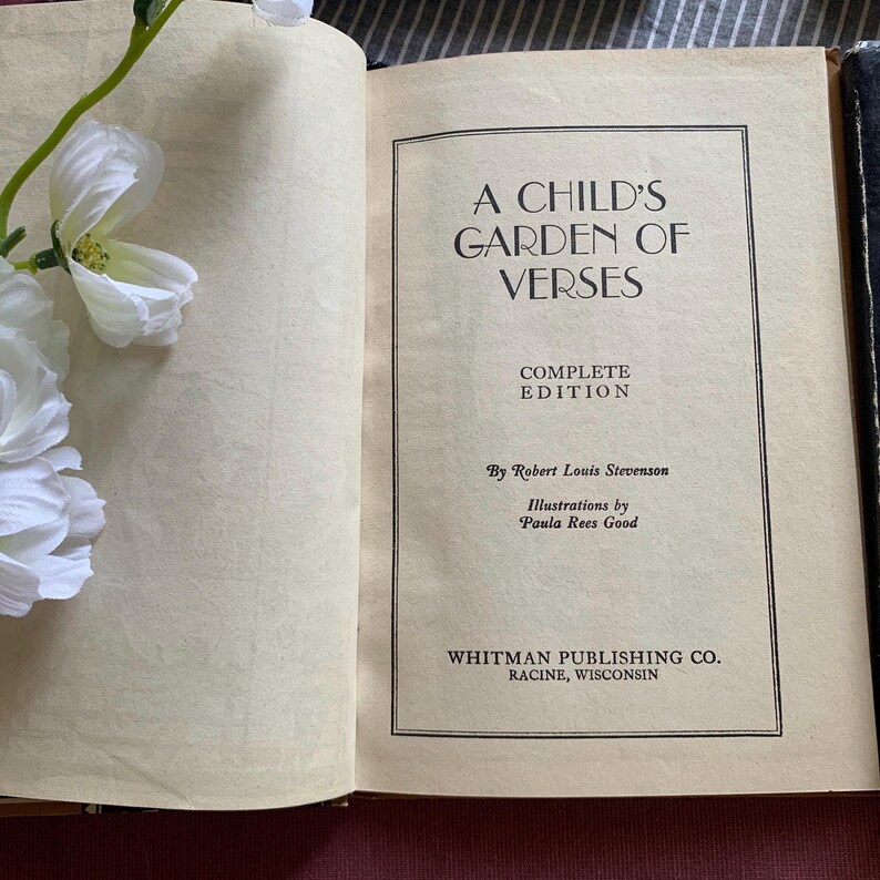 Pu&ograve; includere: Libro aperto intitolato "A Child's Garden of Verses" di Robert Louis Stevenson. L'edizione completa &egrave; pubblicata da Whitman Publishing Co. a Racine, Wisconsin. Fiori bianchi nell'angolo in alto a sinistra.
