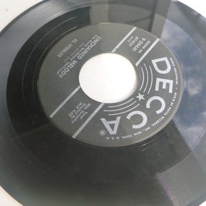 May include: Black and white vinyl record with a label that reads "Decca Records Inc. New York, U.S.A." and "Magnavox Records - Made in U.S.A.". The label also includes the song title "Unchained Melody" by Al Hibbler and the song number "9-29441".
