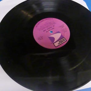 May include: A black vinyl record with a pink label. The label has the text "MARY HOPKIN" and "Those Were The Days" in white. The label also has the text "Marboro Records" in white on a purple background.