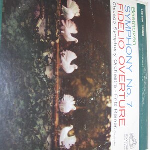 May include: Vintage vinyl record album cover featuring the text "Beethoven Symphony No. 7 Fidelio Overture" with the Chicago Symphony Orchestra. The cover art displays white doves against a backdrop of green foliage and a dark background.