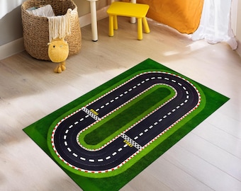 Puede incluir: Una alfombra verde con un diseño de pista de carreras negra. La pista tiene líneas blancas y banderas a cuadros rojas y blancas en las líneas de salida y meta. El texto "START" y "FINISH" está impreso en la alfombra.