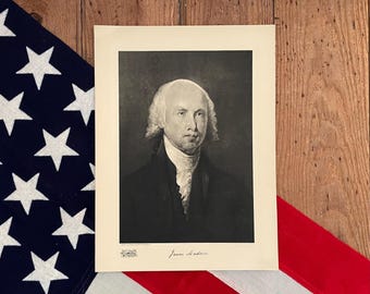 May include: A black and white portrait of James Madison, the fourth president of the United States. The portrait is framed and has a white mat. The image is signed "James Madison".