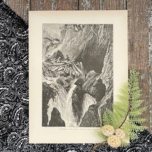 May include: A black and white illustration of a waterfall cascading down a rocky cliff. The image is from an old book and has a vintage feel.