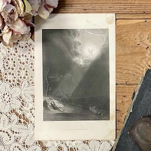 May include: A black and white print of a religious scene depicting an angel ascending to heaven with a woman kneeling on the ground below. The print is titled "Pilgrim's Dream."
