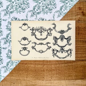 May include: A vintage print featuring nine ornate black and white designs of handles for brass work. The designs vary in shape and detail, with floral and scroll motifs. The print is on aged paper, with the text "16. Designs of Handles for Brass Work".