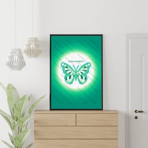 May include: A framed art print featuring a teal butterfly design with white and teal accents, set against a gradient green background. The text "IN MY ELEMENT" is above the butterfly. The artwork is displayed on a wooden dresser.