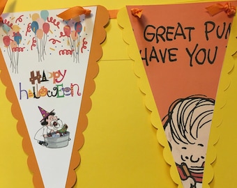 May include: A Halloween banner with two orange and white pennants. One pennant has the words "Happy Halloween" and a witch illustration. The other says "Great Pun Have You" with a cartoon character.