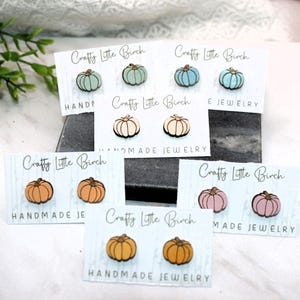 May include: Five cards with the text "Crafty Little Birch" and the words "Handmade Jewelry" on each card. Each card features two small wooden pumpkin earrings in different colors: light blue, pink, orange, and brown.