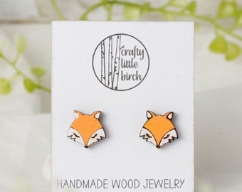 May include: A pair of wooden fox earrings on a white card with the text "crafty little birch" and "HANDMADE WOOD JEWELRY".