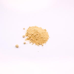 以下が含まれることがあります： 白い背景に置かれた、薄い茶色の粉末の山