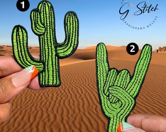 May include: Two embroidered patches: a green cactus and a green hand making a rock and roll gesture. Both patches have black outlines and are set against a desert backdrop. The patches are labeled 1 and 2.