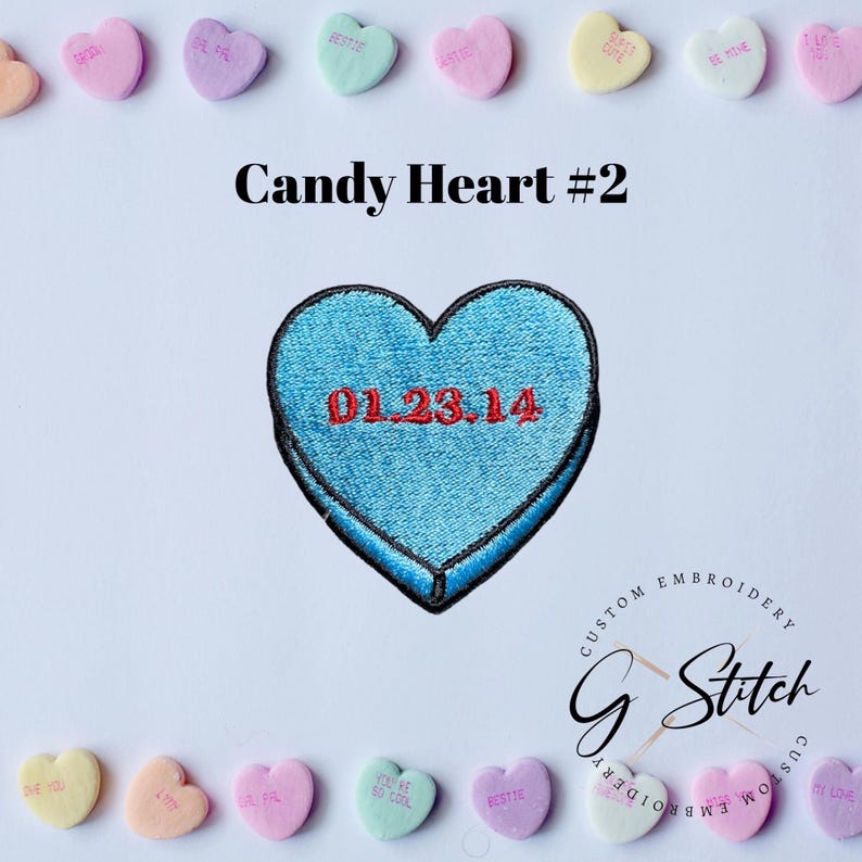 May include: A light blue embroidered heart-shaped patch with the date 01.23.14 in red. The patch is surrounded by various pastel-coloured candy hearts with phrases like "BESTIE" and "BE MINE". The text "Candy Heart #2" is above the patch.