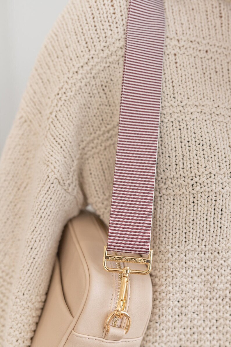 A dark purple and white striped bag strap.