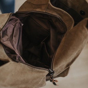 An interior shot of a canvas hobo bag showing the two sections and middle zipper.