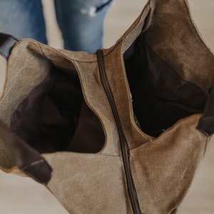 An interior shot of a canvas hobo bag showing the two sections and middle zipper.