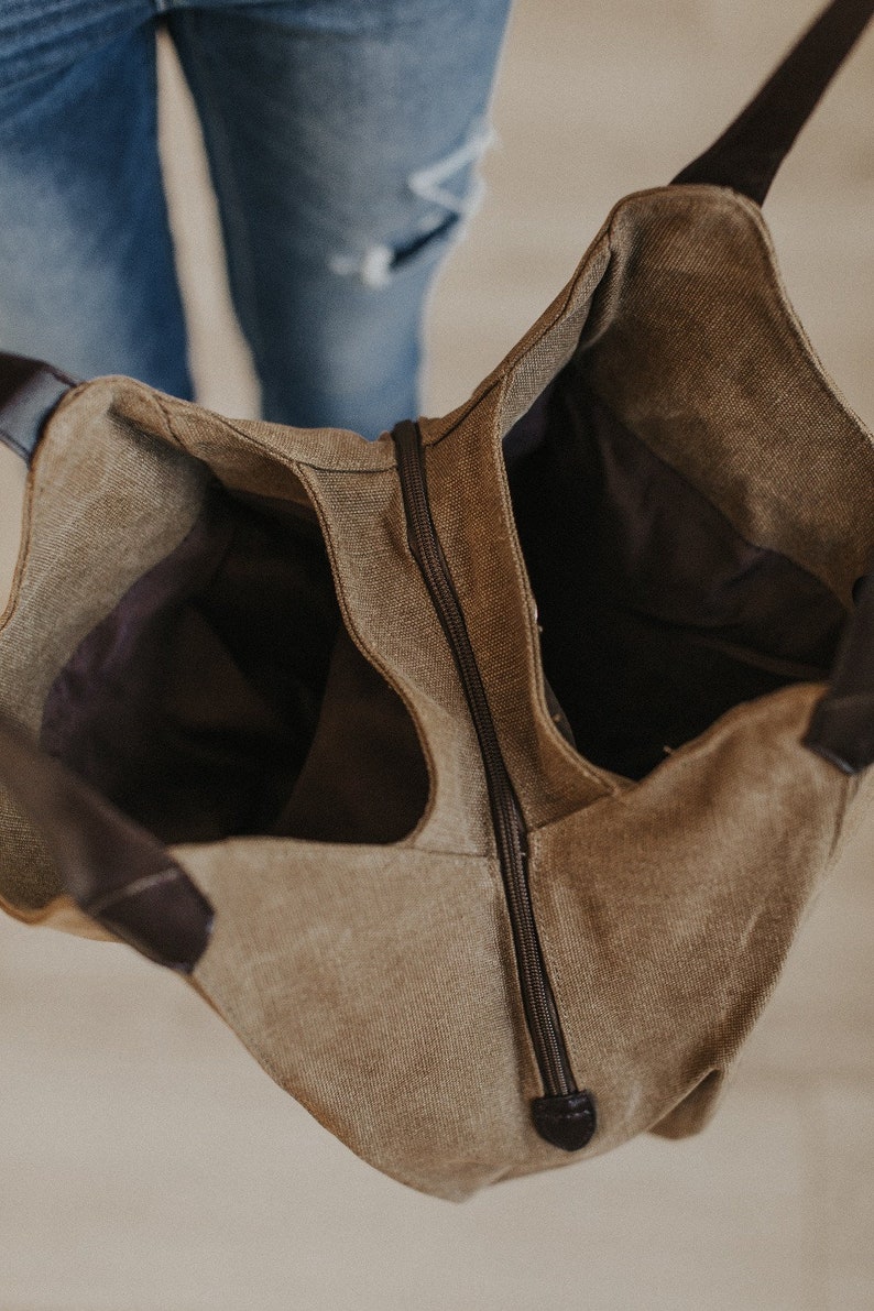An interior shot of a canvas hobo bag showing the two sections and middle zipper.
