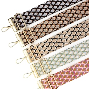 May include: Five different patterned fabric straps with gold metal clasps. The straps have a repeating pattern of overlapping scales in various colors, including brown, beige, green, and pink.
