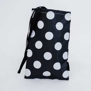May include: A black drawstring bag with a white polka dot pattern.