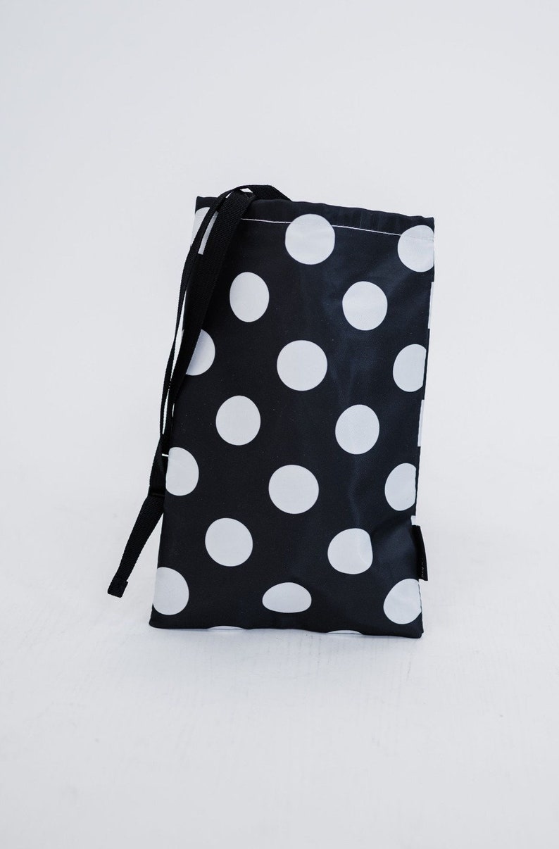 May include: A black drawstring bag with a white polka dot pattern.
