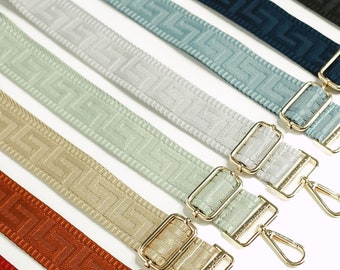 May include: A set of seven woven straps in various colors, including light blue, gray, beige, and orange. Each strap has a gold metal buckle and a gold metal clasp.