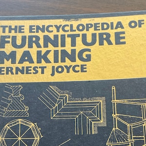 May include: A gold and black book titled "The Encyclopedia of Furniture Making" by Ernest Joyce. The cover features illustrations of furniture designs.