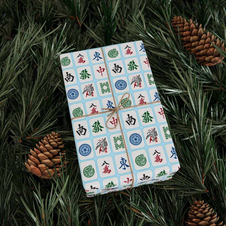 Flat image of unrolled 24 in x 36 in wrapping paper with white Mahjong tiles on a light blue background