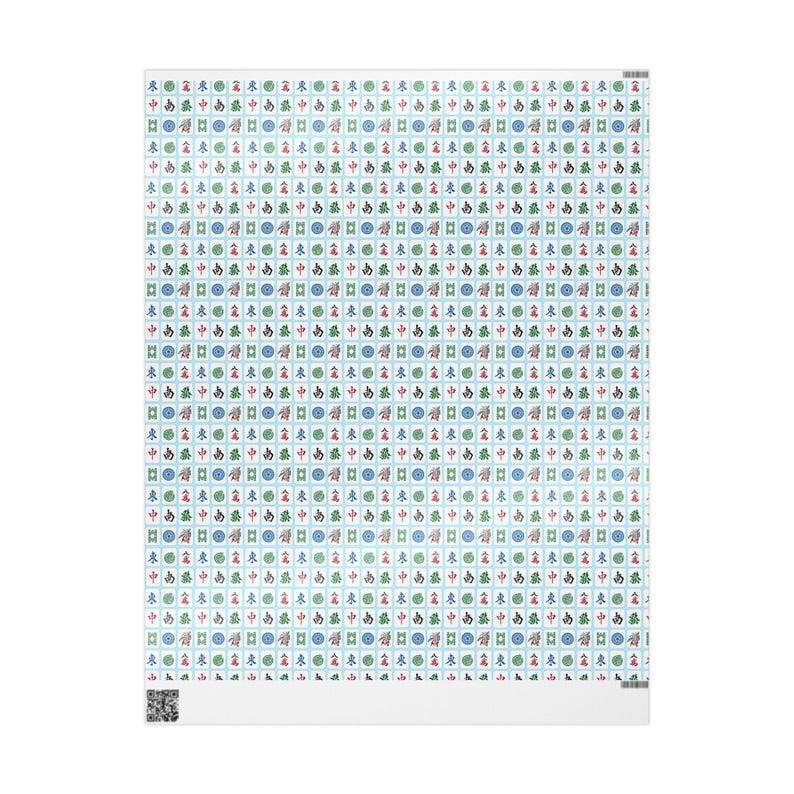 Close up of wrapping paper with white Mahjong tiles on a light blue background. There are also green and gold ribbons and the side of a white box.