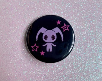 Puede incluir: Un botón redondo negro con un diseño de conejito lavanda estilizado y estrellas rosas. El conejito tiene ojos grandes y orejas largas. El botón tiene un acabado brillante y está sobre un fondo rosa brillante.