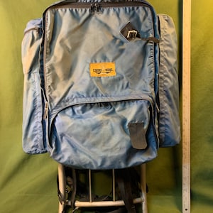 May include: A blue camping backpack with a metal frame and the logo "camp-ways" on the front.