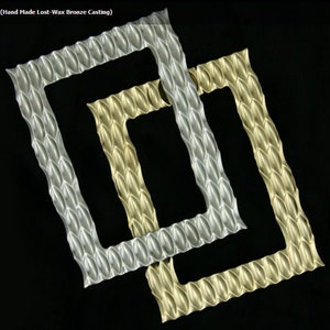 May include: Two picture frames, one silver and one gold, with a textured, honeycomb-like design. The frames are overlapping and are on a black background.