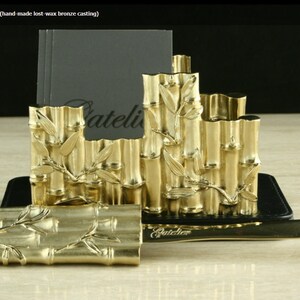 May include: Gold-toned bamboo letter holder with a matching letter opener. The holder is made of lost-wax bronze casting and features a detailed bamboo design.