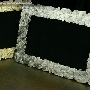 May include: Two silver picture frames with a ginkgo leaf design. The frame on the left is a lighter shade of silver and the frame on the right is a darker shade of silver.