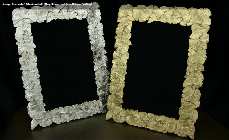 May include: Two 4x6 inch picture frames made of bronze casting. The frames are decorated with a ginkgo leaf design. One frame is titanium gold and the other is silver.