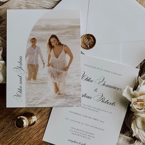 May include: Wedding stationery set with a photograph of a couple in the sea, and the names "Chloe and Joshua". The set includes an invitation, an envelope with a gold seal, and a card with event details.