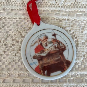 JCPenney 1996 Exclusive Porcelain Norman Rockwell Christmas Ornament called Santa Reading Letters, White Porcelain with Gold Trim Decoration